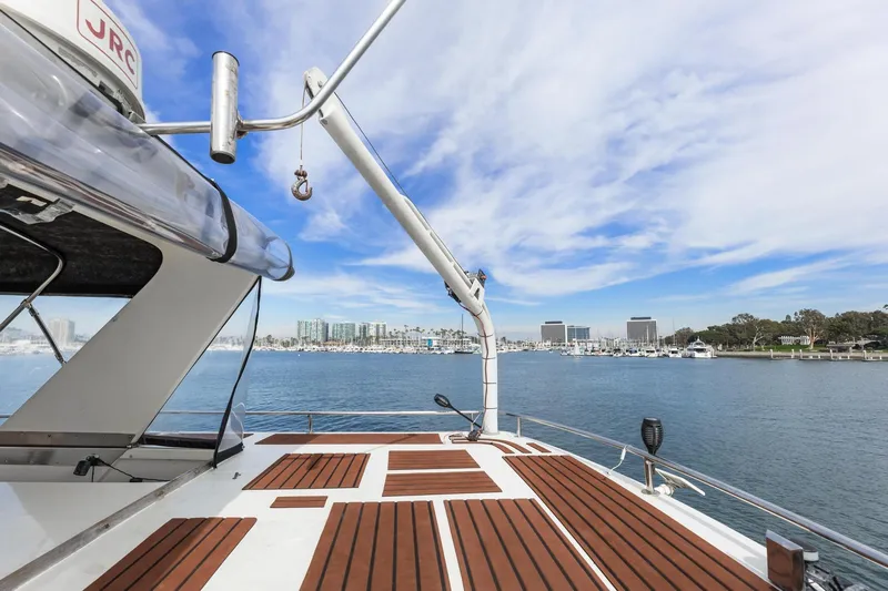 Slide: The Image of 1988 Marine Trader Trawler deck with scenic marina view under blue sky. - 51