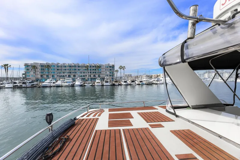 Slide: The Image of 1988 Marine Trader Trawler docked at marina with waterfront view and blue sky. - 52