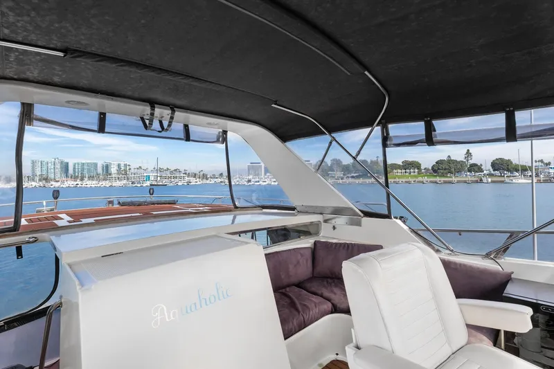 Slide: The Image of 1988 Marine Trader Trawler interior with seating, overlooking marina and waterfront views. - 56