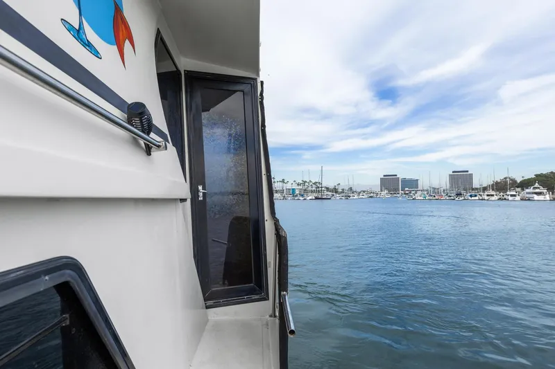 Slide: The Image of 1988 Marine Trader Trawler docked at marina with cityscape in background. - 9