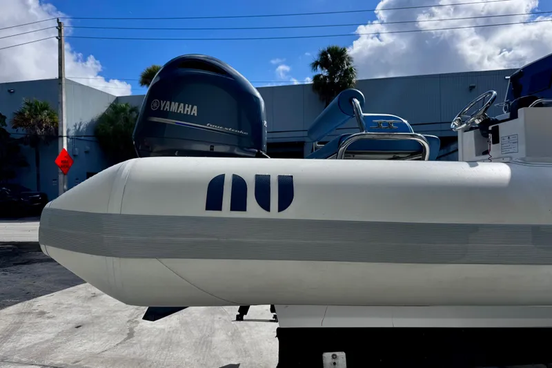 Slide: The Image of 2023 Novurania Catamaran 20 with Yamaha engine, parked outdoors under a blue sky. - 4