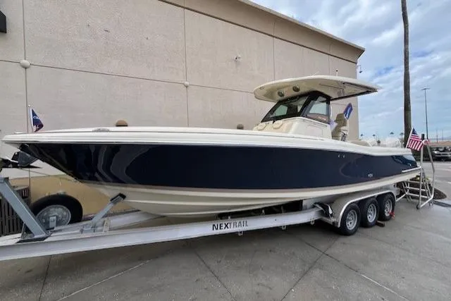 The Image of 2026 Chris-Craft Catalina 31 boat on trailer, sleek design, navy hull, outdoor display. - 0