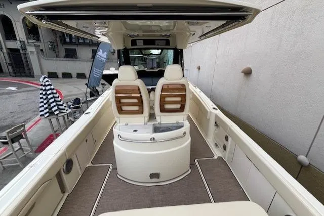 Slide: The Image of 2026 Chris-Craft Catalina 31 boat interior with seating and helm, docked near a building. - 10