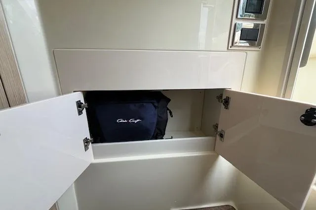 Slide: The Image of 2026 Chris-Craft Catalina 31 storage compartment with open doors and branded bag inside. - 15