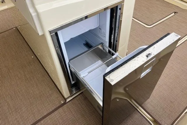 Slide: The Image of 2026 Chris-Craft Catalina 31 boat interior with open stainless steel drawer fridge. - 16