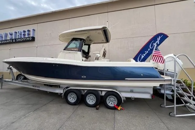 Slide: The Image of 2026 Chris-Craft Catalina 31 boat on trailer, parked near shopping center. - 2