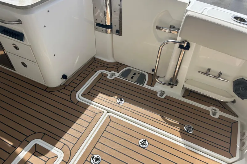 Slide: The Image of 2017 Boston Whaler 320 Vantage boat deck with wood finish and storage compartments. - 15