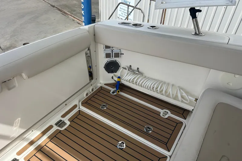 Slide: The Image of 2017 Boston Whaler 320 Vantage interior with teak flooring and coiled hose. - 16