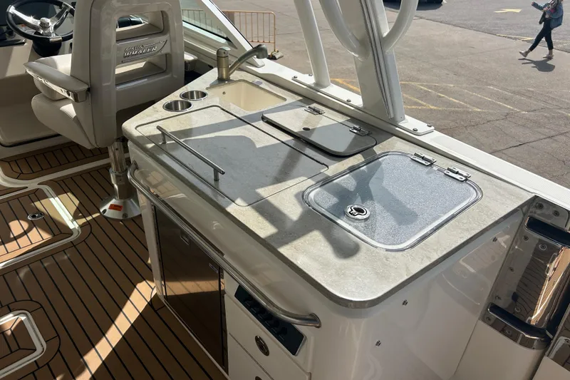 Slide: The Image of 2017 Boston Whaler 320 Vantage boat interior with helm and kitchenette area. - 19