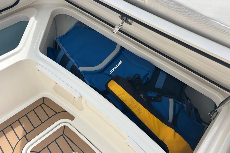 Slide: The Image of Storage compartment on 2017 Boston Whaler 320 Vantage with life jackets and gear. - 21
