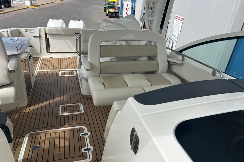 Slide: The Image of 2017 Boston Whaler 320 Vantage boat interior with cushioned seating and wood-patterned flooring. - 28