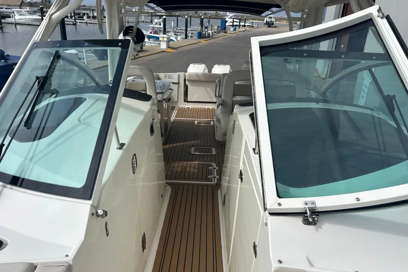 Slide: The Image of 2017 Boston Whaler 320 Vantage boat interior with open windshield and wooden deck. - 29