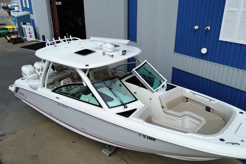 Slide: The Image of 2017 Boston Whaler 320 Vantage boat docked near a blue building. - 3