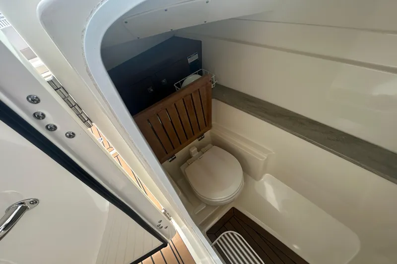 Slide: The Image of Interior of 2017 Boston Whaler 320 Vantage boat bathroom with wooden accents. - 30