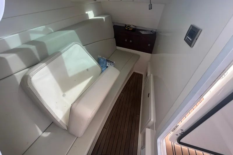 Slide: The Image of 2017 Boston Whaler 320 Vantage cabin interior with seating and wooden flooring. - 34