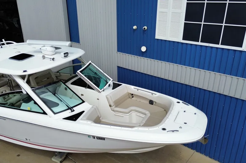 Slide: The Image of 2017 Boston Whaler 320 Vantage boat docked near blue building. - 5