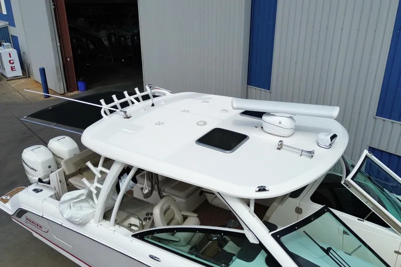 Slide: The Image of 2017 Boston Whaler 320 Vantage boat with dual engines, docked near a warehouse. - 6
