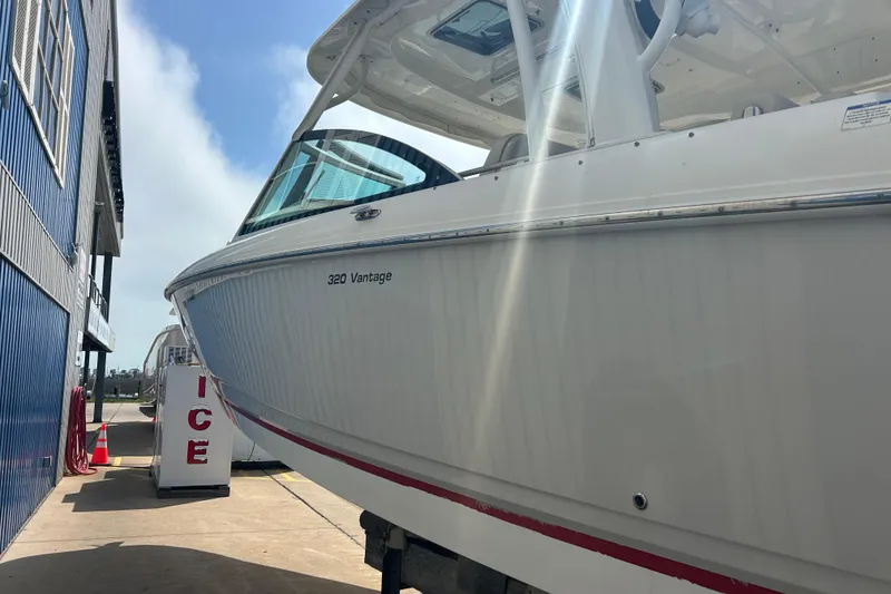 Slide: The Image of 2017 Boston Whaler 320 Vantage boat docked near a building under sunlight. - 9