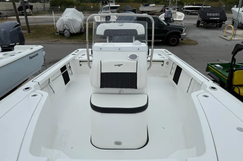 Slide: The Image of 2026 Tidewater 1910 Bay Max boat interior with seating and console, parked in a marina. - 3
