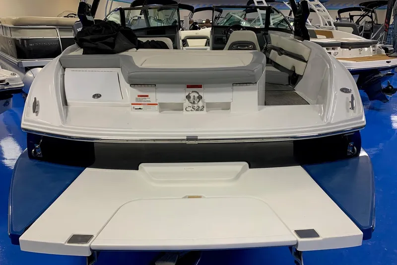 Slide: The Image of 2019 Cobalt CS22 boat interior, showcasing seating and deck in a showroom setting. - 6