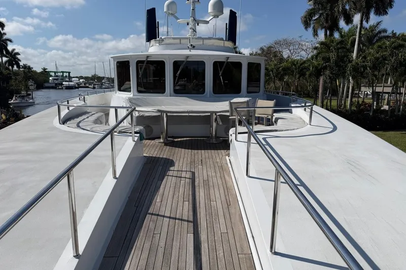 Slide: The Image of Luxury Heesen 144 yacht deck, 1990 model, with sleek design and scenic waterway view. - 11