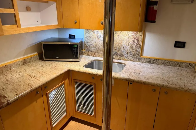 Slide: The Image of Compact yacht kitchen with granite countertops, microwave, and sink on a 1990 Heesen 144 model. - 112