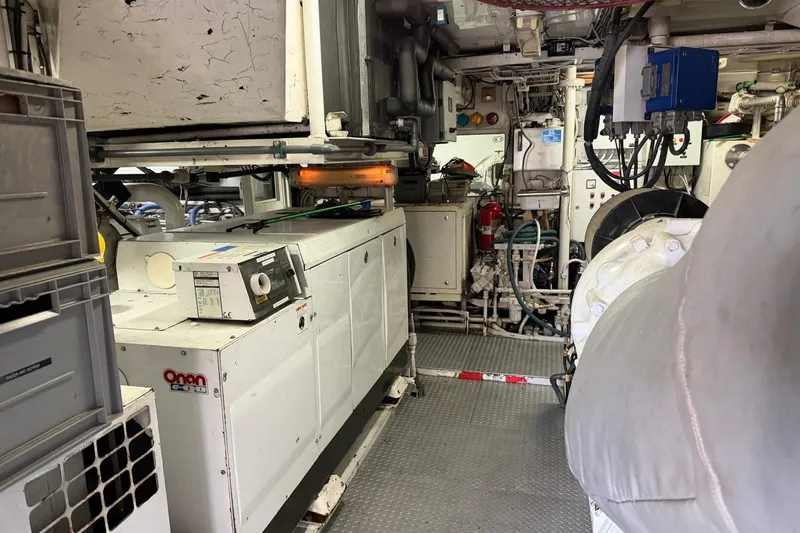 Slide: The Image of Engine room of a 1990 Heesen 144 yacht, featuring Onan generator and complex machinery. - 119