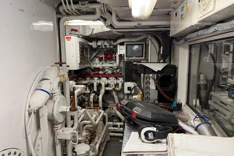 Slide: The Image of Engine room of a 1990 Heesen 144 yacht with complex machinery and control panels. - 125