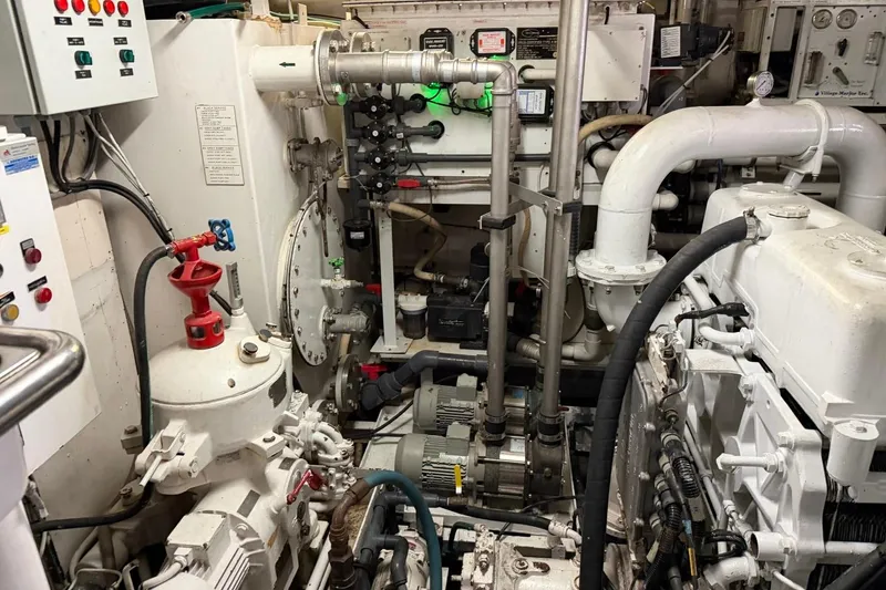 Slide: The Image of Engine room of a 1990 Heesen 144 yacht, featuring complex machinery and piping systems. - 131