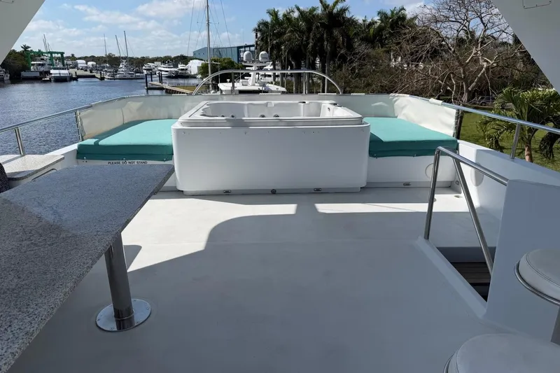 Slide: The Image of Luxurious Heesen 144 yacht deck with jacuzzi and seating, docked by a scenic marina. - 18