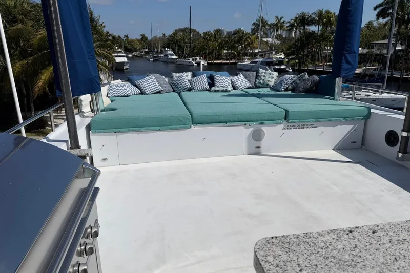 Slide: The Image of Luxurious Heesen 144 yacht deck with sunbathing area, cushions, and scenic marina view. - 19