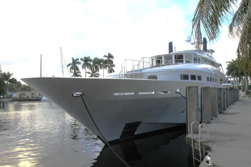 Slide: The Image of Luxury Heesen 144 yacht docked, 1990 model, surrounded by palm trees. - 2