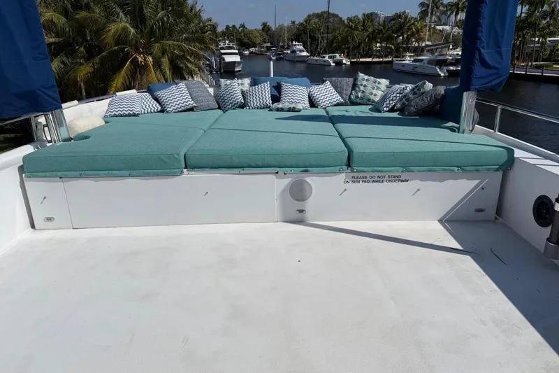 Slide: The Image of Luxurious sun pad on 1990 Heesen 144 yacht with cushions and pillows, docked near palm trees. - 20