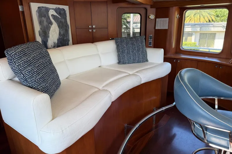 Slide: The Image of Luxurious Heesen 144 yacht interior with white sofa, blue chair, and elegant wood paneling. - 29