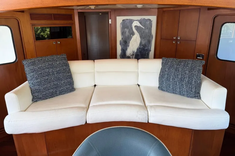 Slide: The Image of Luxurious Heesen 144 yacht interior with white sofa, decorative pillows, and elegant wood paneling. - 31