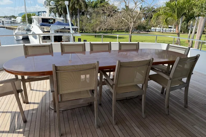 Slide: The Image of Outdoor dining area on 1990 Heesen 144 yacht with wooden table and chairs. - 5