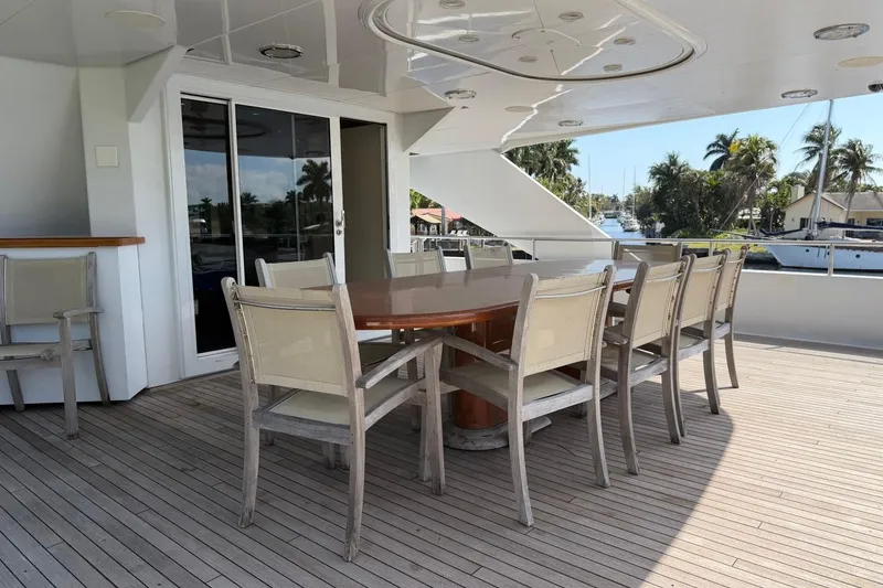 Slide: The Image of Outdoor dining area on 1990 Heesen 144 yacht with wooden table and chairs. - 7