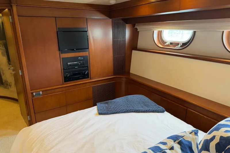 Slide: The Image of Luxurious Heesen 144 yacht bedroom interior with wood paneling and porthole window, 1990 model. - 73