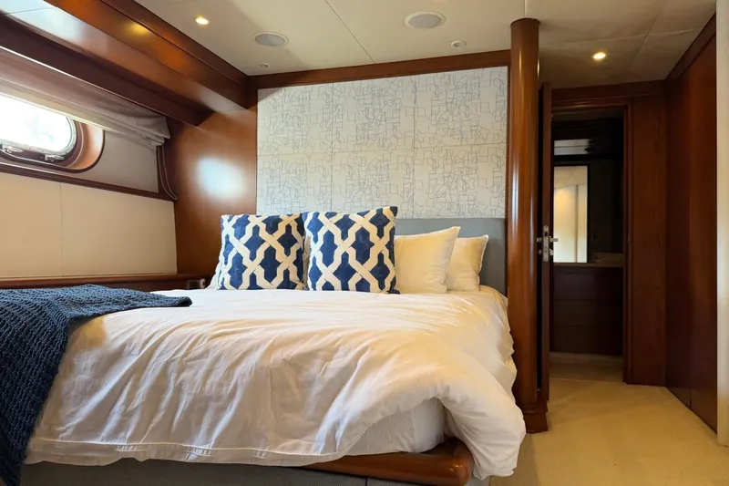 Slide: The Image of Luxurious bedroom interior on a 1990 Heesen 144 yacht, featuring elegant bedding and wood accents. - 74