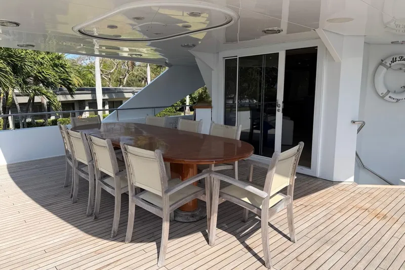 Slide: The Image of Outdoor dining area on 1990 Heesen 144 yacht with wooden table and chairs. - 8