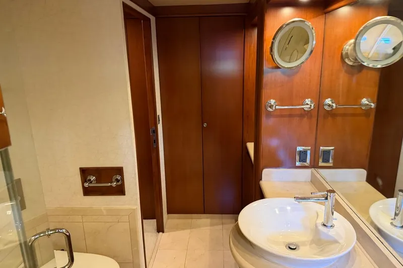 Slide: The Image of Luxurious yacht bathroom with wooden accents, round mirrors, and modern sink. Heesen 144, 1990. - 80