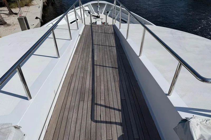 Slide: The Image of Deck view of 1990 Heesen 144 yacht with wooden flooring and metal railings. - 9