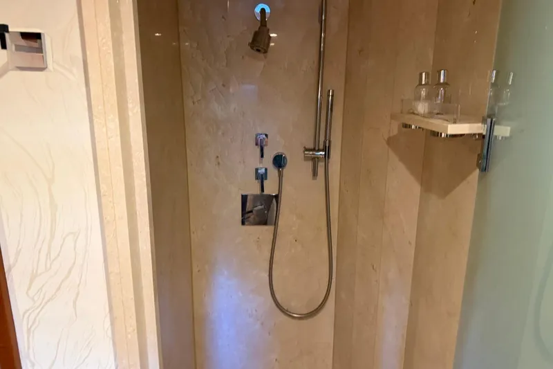 Slide: The Image of Luxurious shower in a 1990 Heesen 144 yacht, featuring elegant marble walls and modern fixtures. - 98