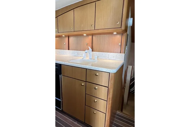 Slide: The Image of 2002 Ocean Yachts 56 Super Sport kitchen with wooden cabinets and countertop sink. - 11