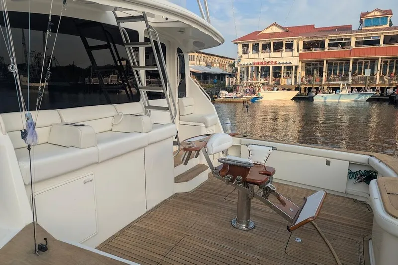 Slide: The Image of 2002 Ocean Yachts 56 Super Sport fishing deck with seating, docked near waterfront buildings. - 80