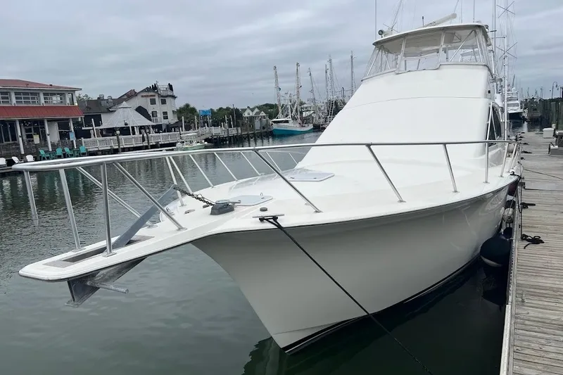 Slide: The Image of 2002 Ocean Yachts 56 Super Sport docked at a marina, showcasing sleek design and spacious deck. - 82