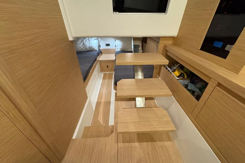 Slide: The Image of Interior of 2025 Pardo Yachts P38, featuring modern wooden design and compact sleeping area. - 21