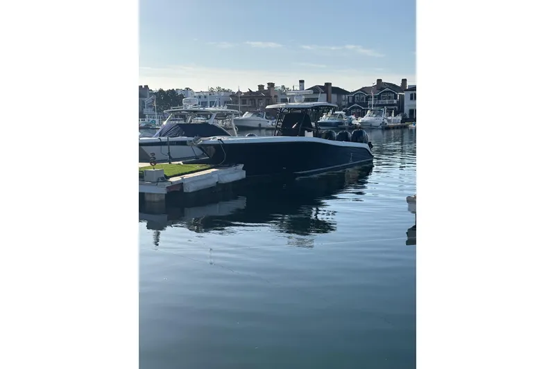 The Image of 2004 Hydra-Sports 3400 CC boat docked in a marina, calm water reflection. - 1