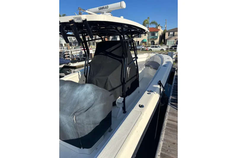 Slide: The Image of 2004 Hydra-Sports 3400 CC boat docked, featuring covered seating and navigation equipment. - 3