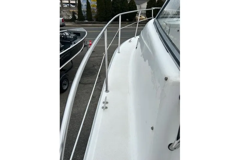 Slide: The Image of 2005 Sea Fox 230 Walk Around boat docked, viewed from the bow under cloudy skies. - 11